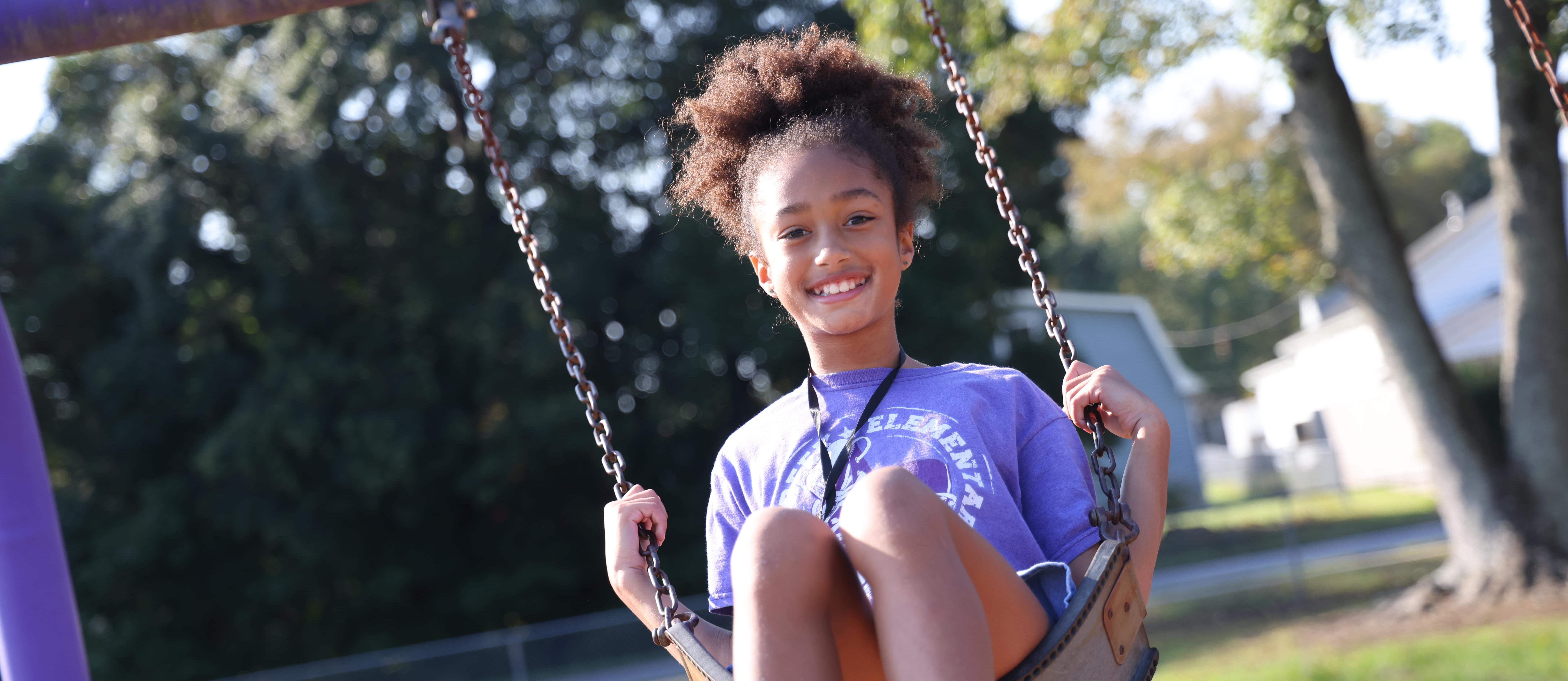 A student uses the swings at recess