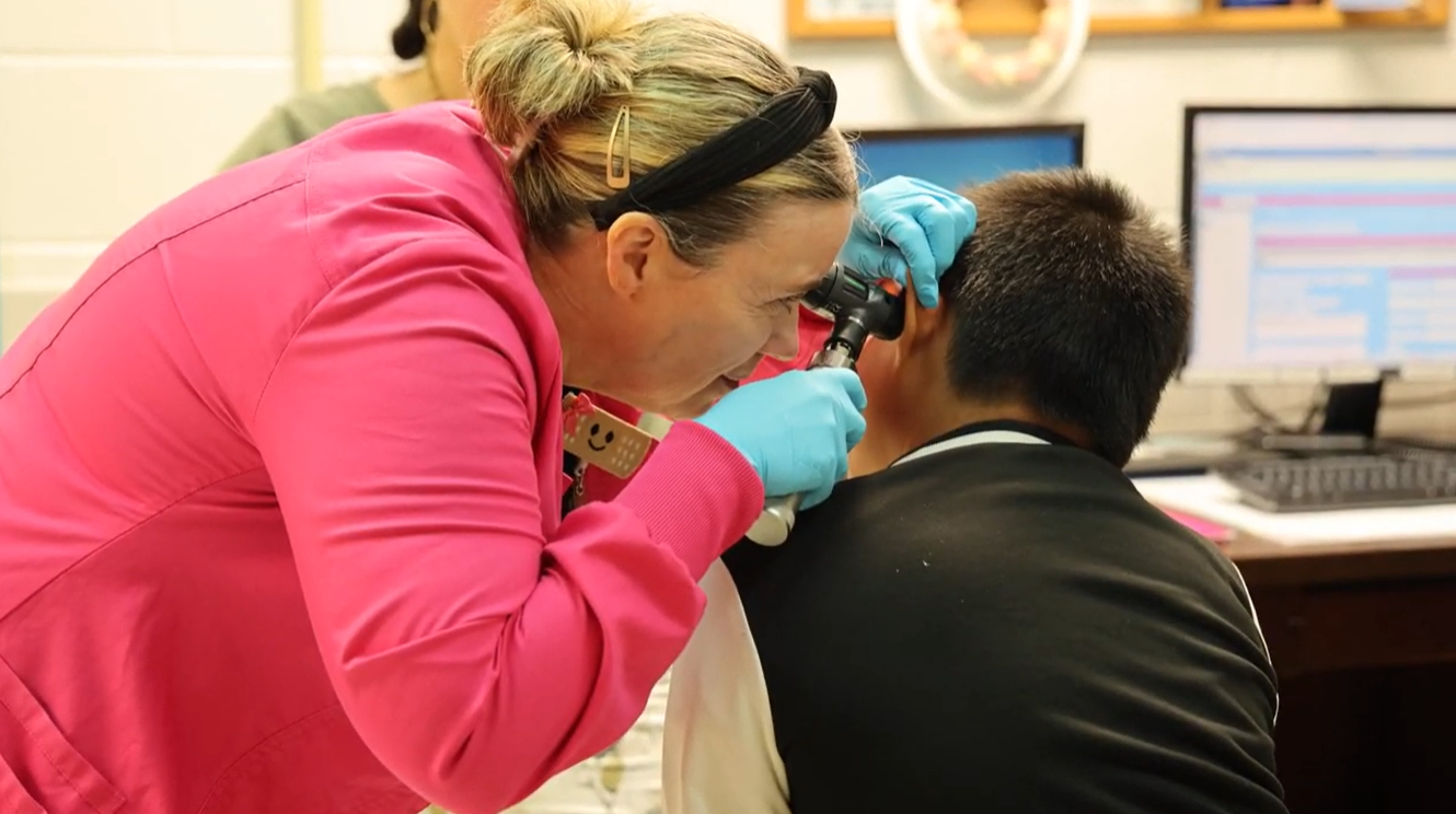 A school nurse tends to an ill student