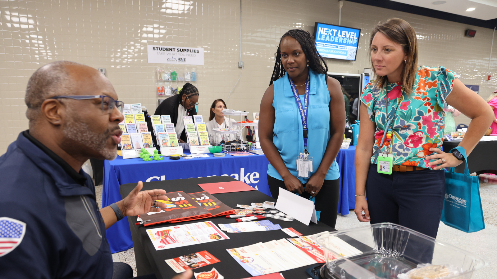 Two staff members visit a resources fair