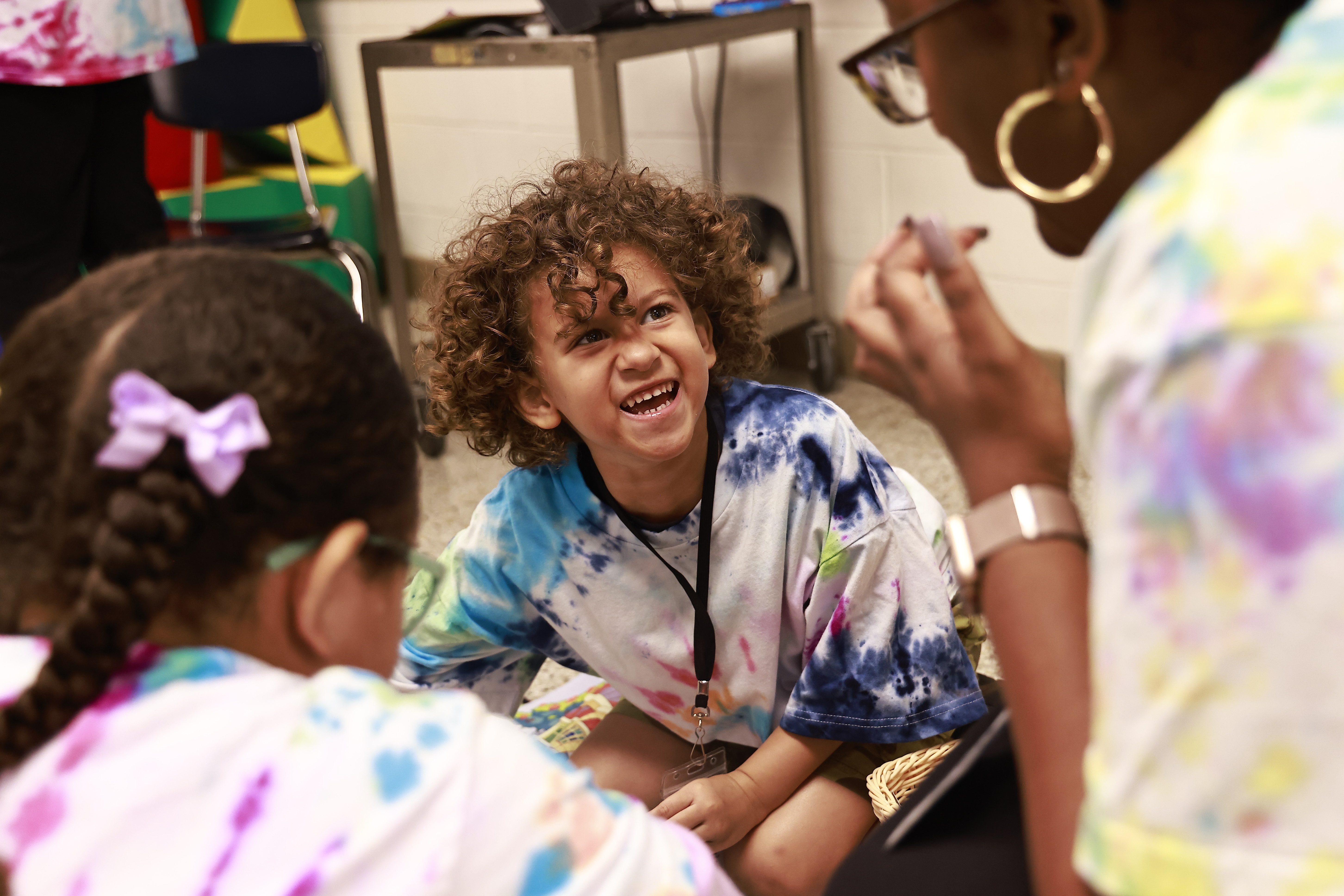 A young student smiles while participating in a  hands-on activity