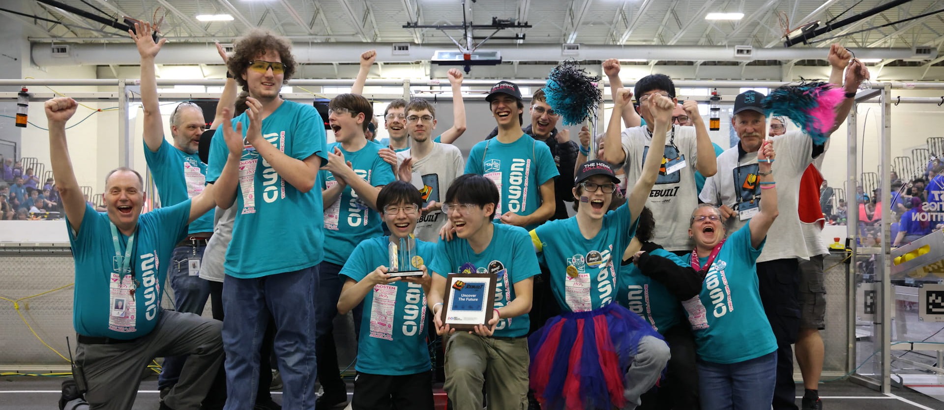 A robotics team celebrates while taking a group photo after winning an award during competition 