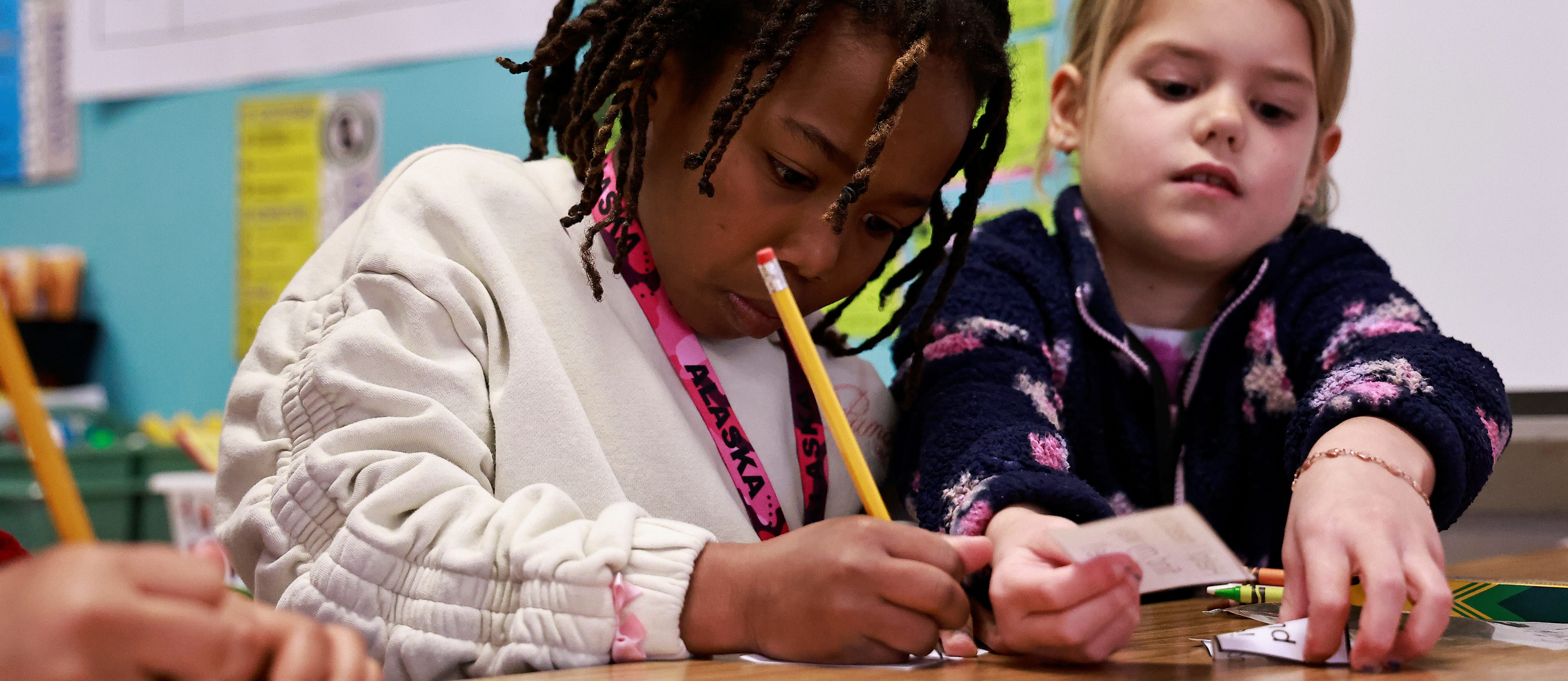 A young student works on an assignment with a classmate