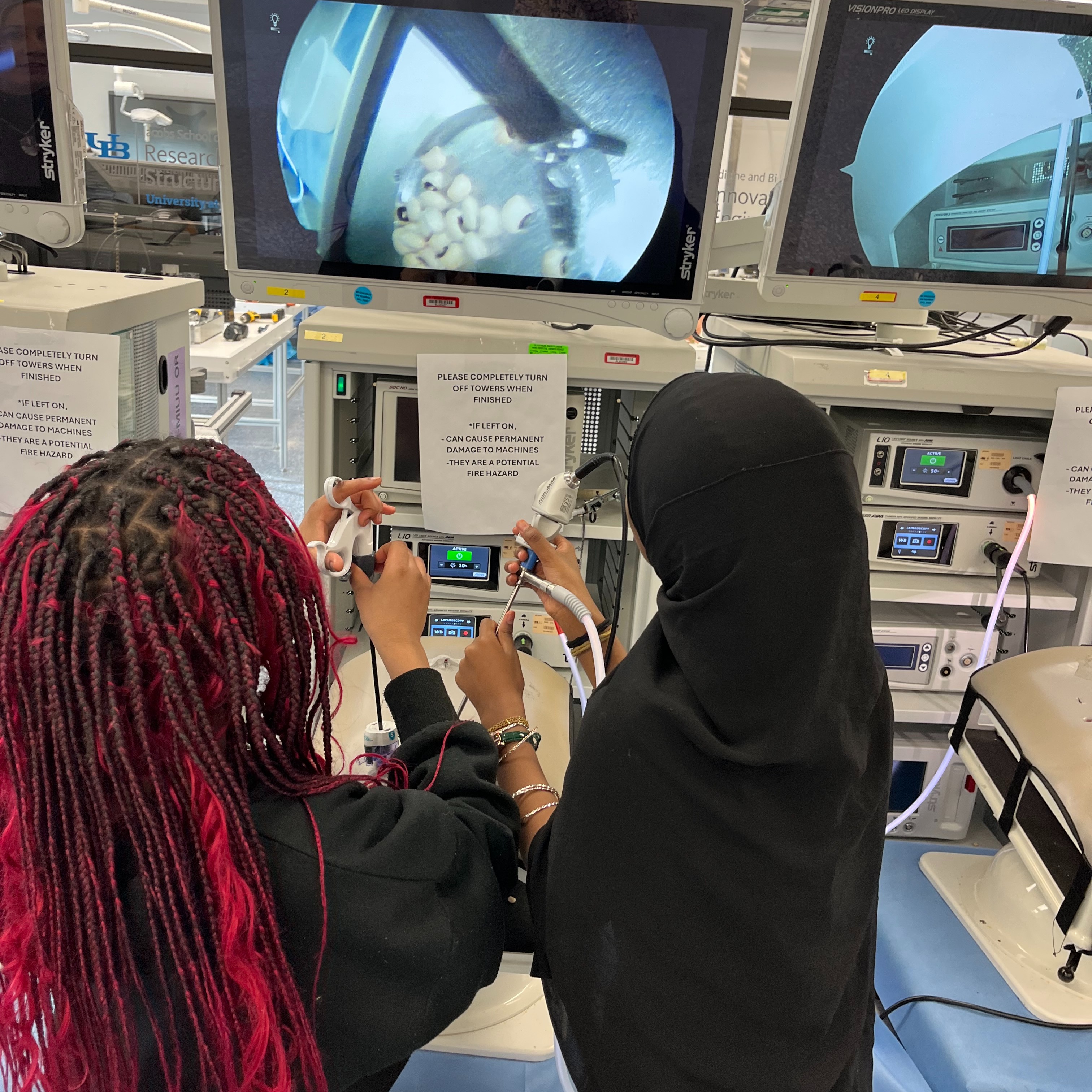 Students at the Pea Drop station training laparoscopic surgury techniques