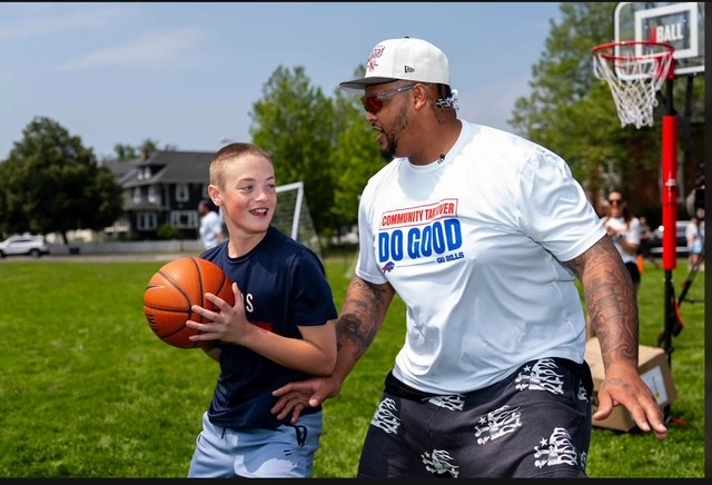 dion dawkins playing basketball with student