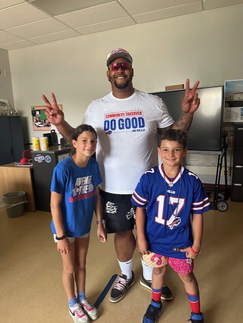 dion dawkins posing with 2 students