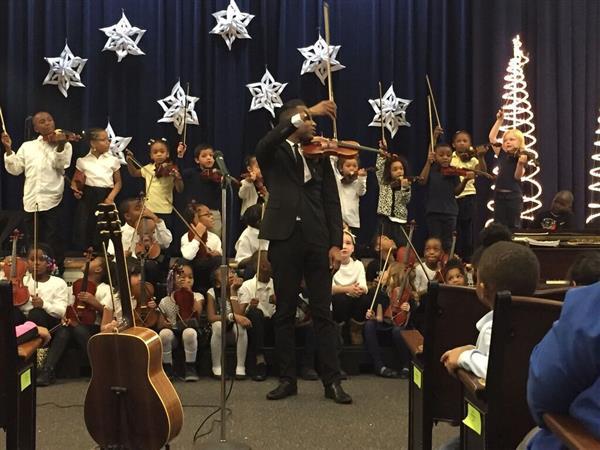 students on stage playing the violin