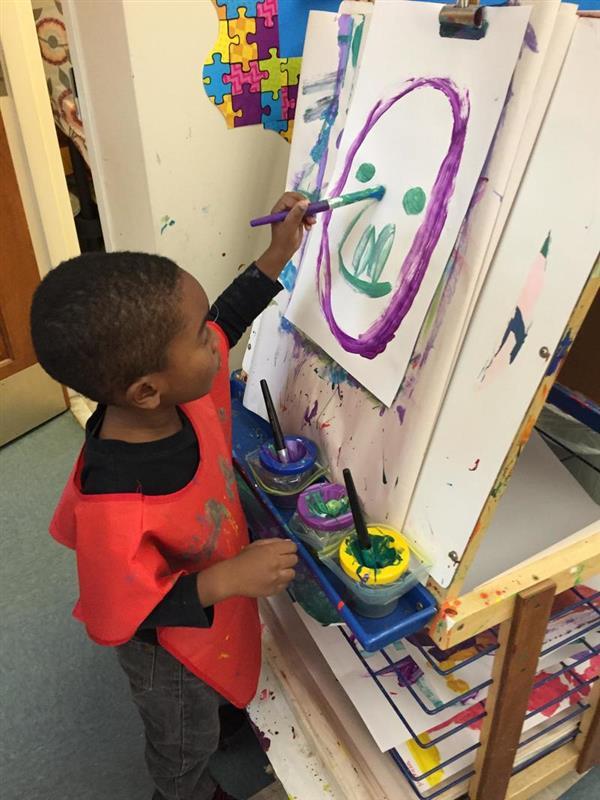 student paining a smiley face