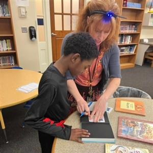 Librarian with student looking at book from Book Vending Machine