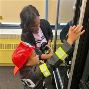 Teacher and Student with Firefighter gear using Book Vending Machine