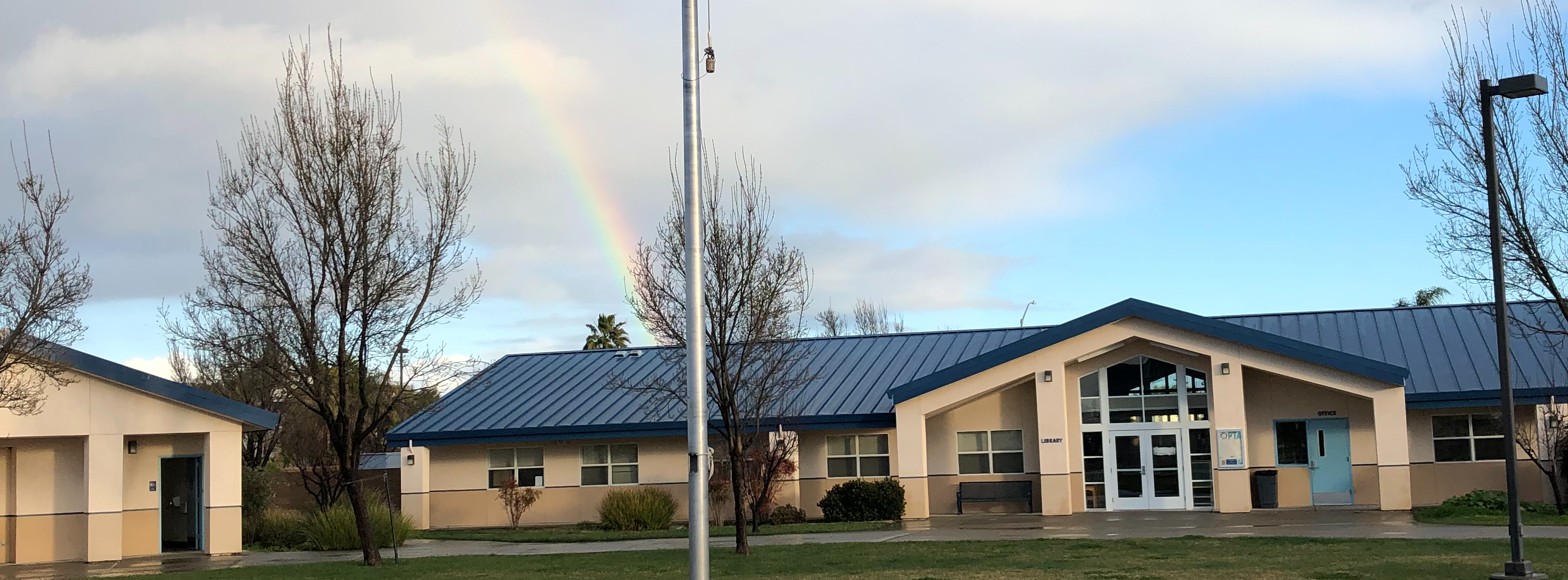 school with rainbow and flags