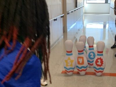 Student bowling in the hallway