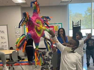 student hitting a piñata 