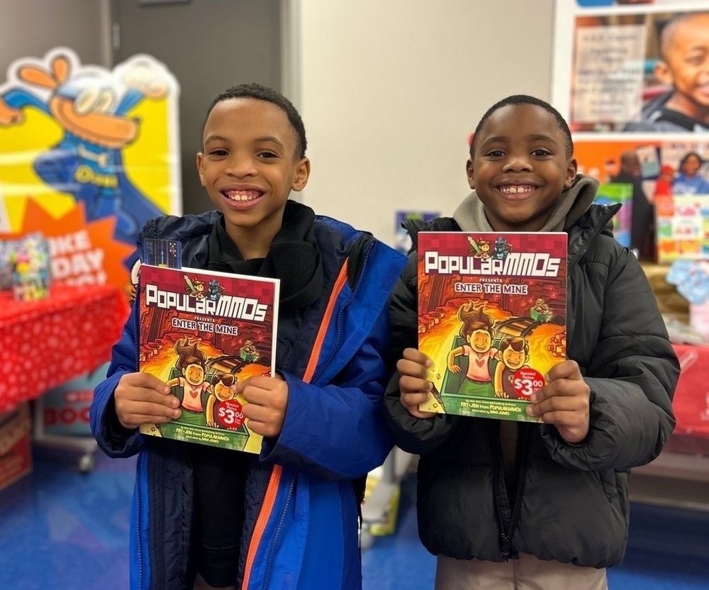 two students holding a book