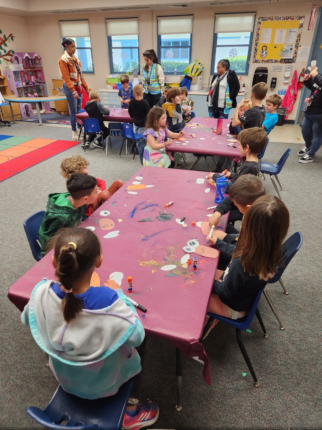 Kids at camp doing art around a large table