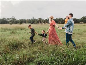 A family of five walks through a field together