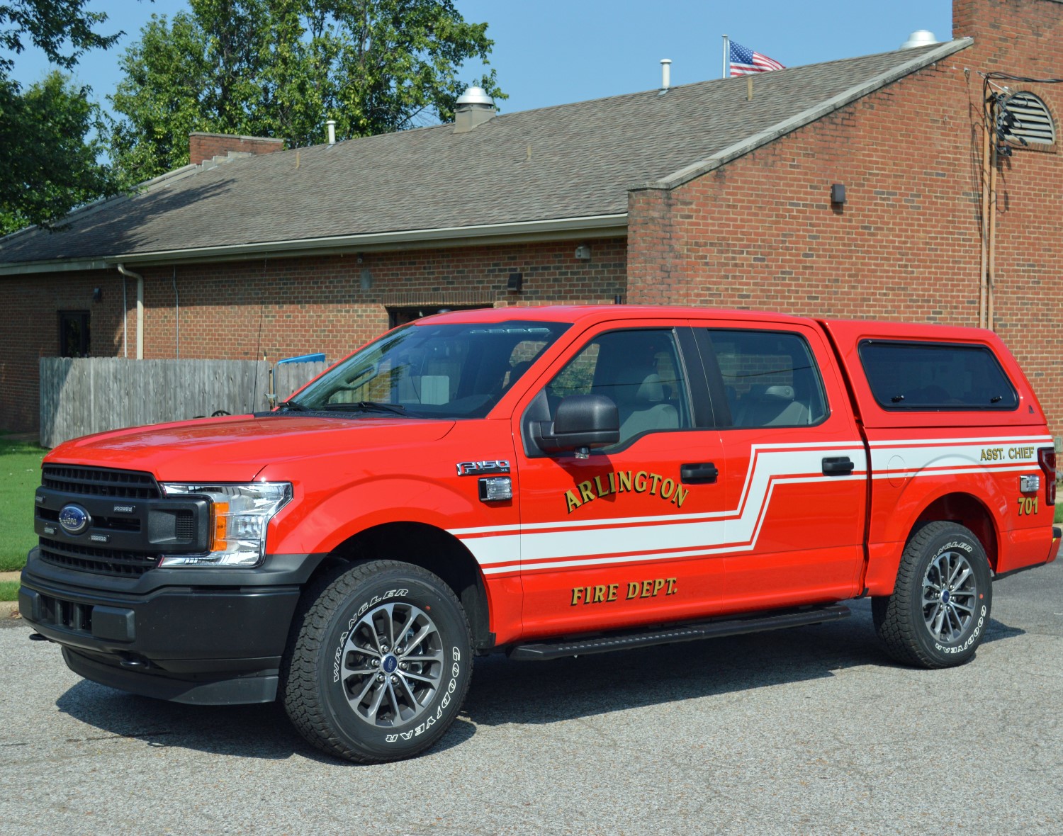 Red fire pickup truck parked in front of a brick building