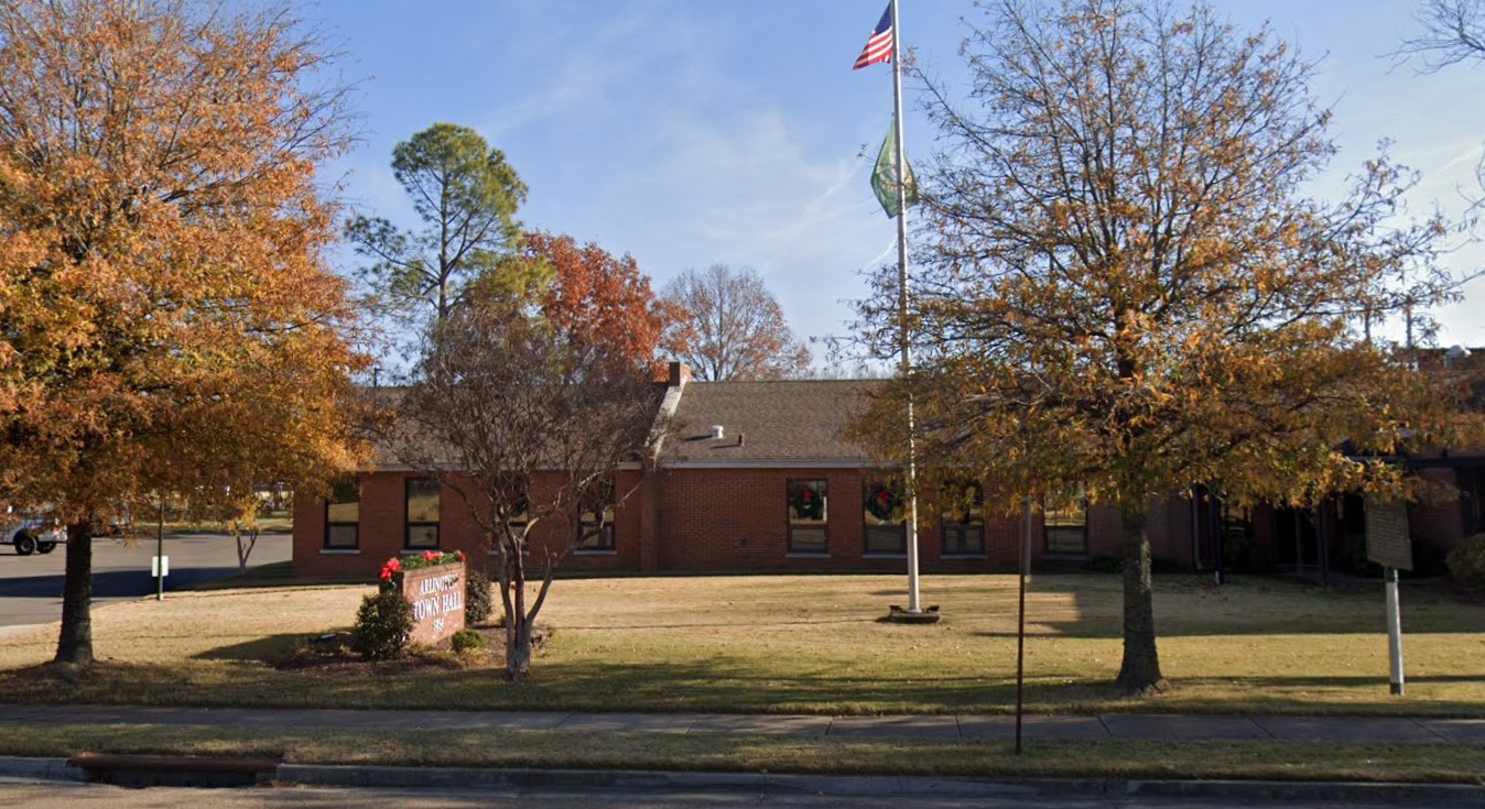 front view of Arlington Town Hall with sign and flag pole in front, and trees with fall colors