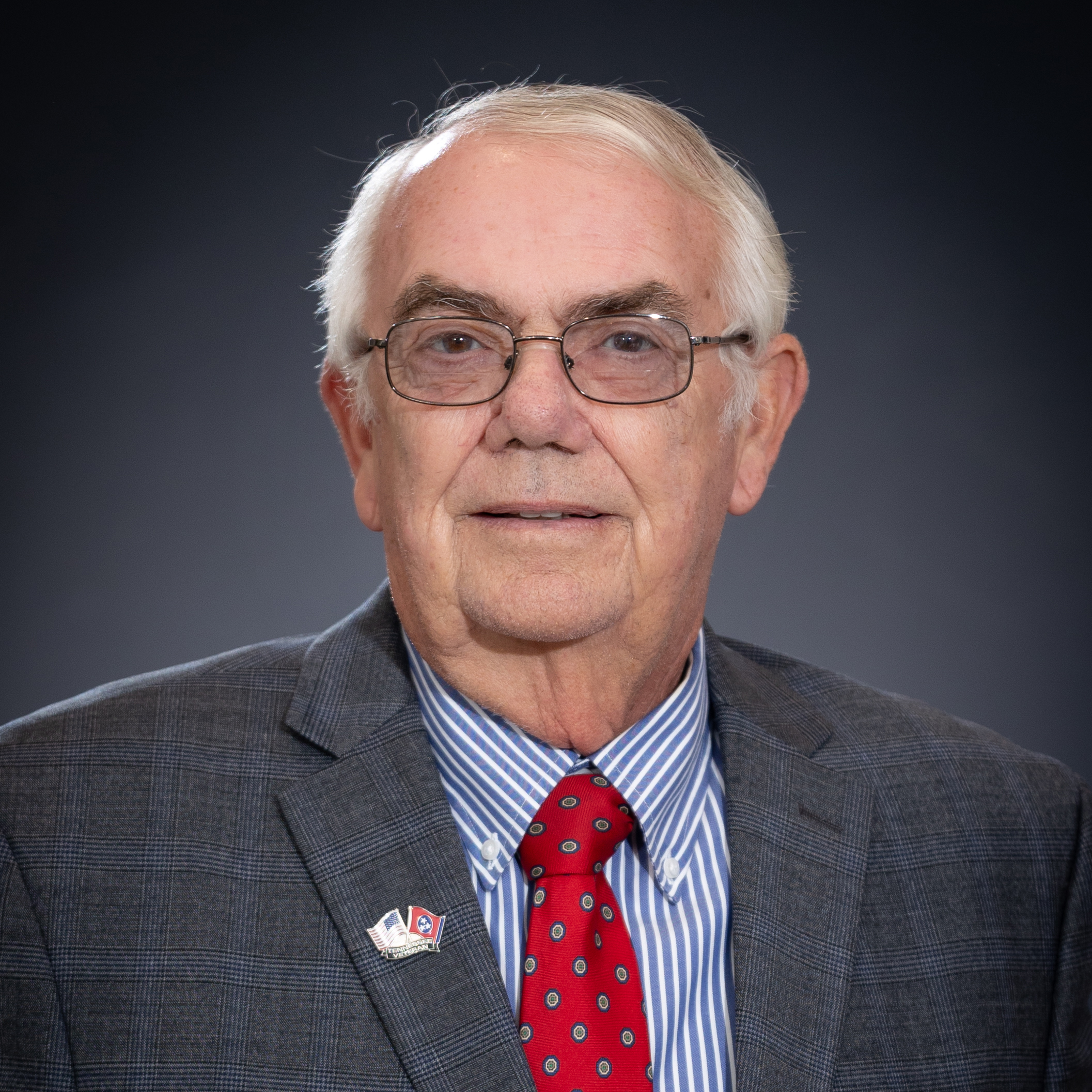 Headshot of Vice Mayor Harry McKee in gray suit with red tie and blue striped shirt