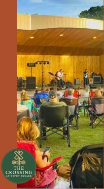 Picture of musicians on a stage with people in lawn chairs in the grass watching