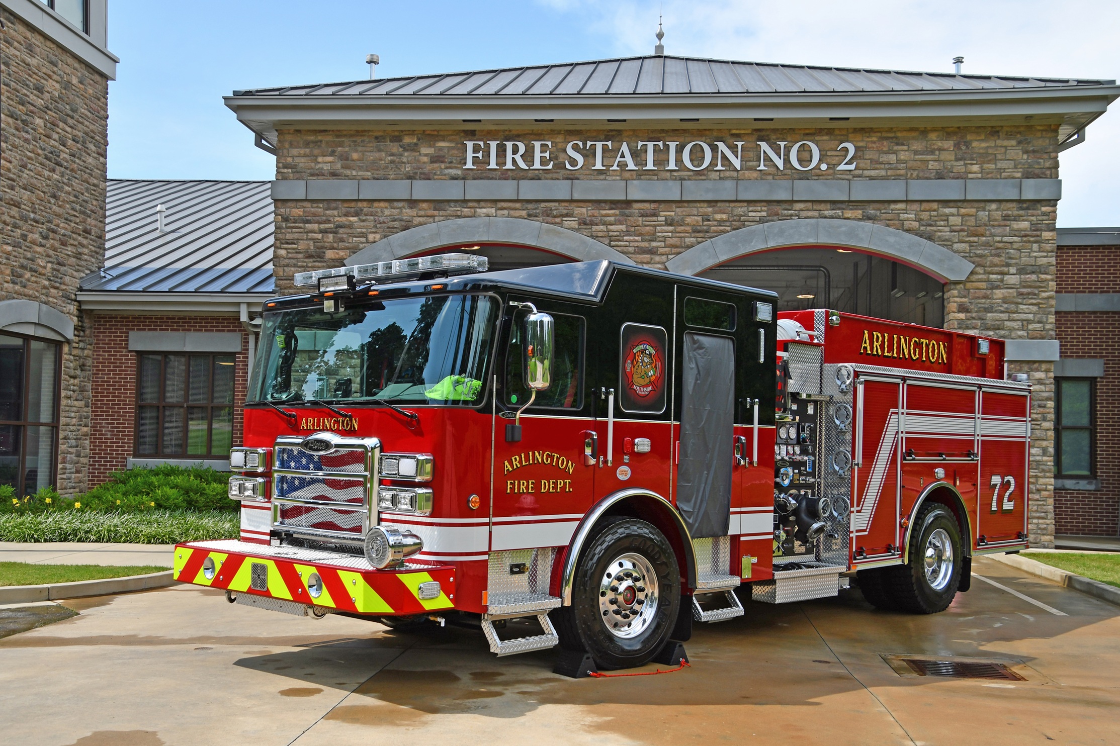 Picture of shiny, red and black Arlington Fire Department Engine #72, parked in front of a brick and stone building with sign reading Fire Station No. 2 above 2 bay doors.