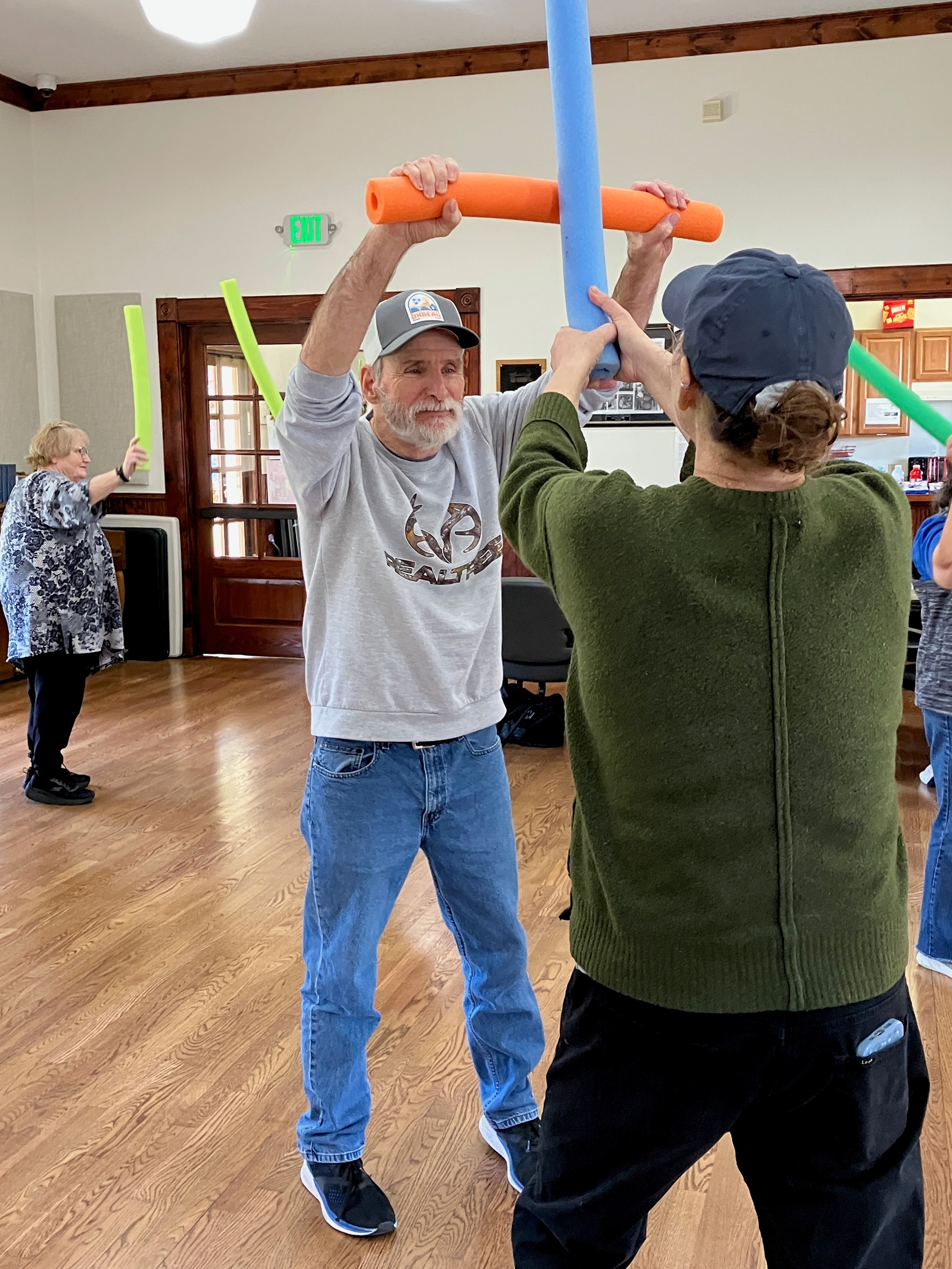 Man pretend sword fighting with pool noodle