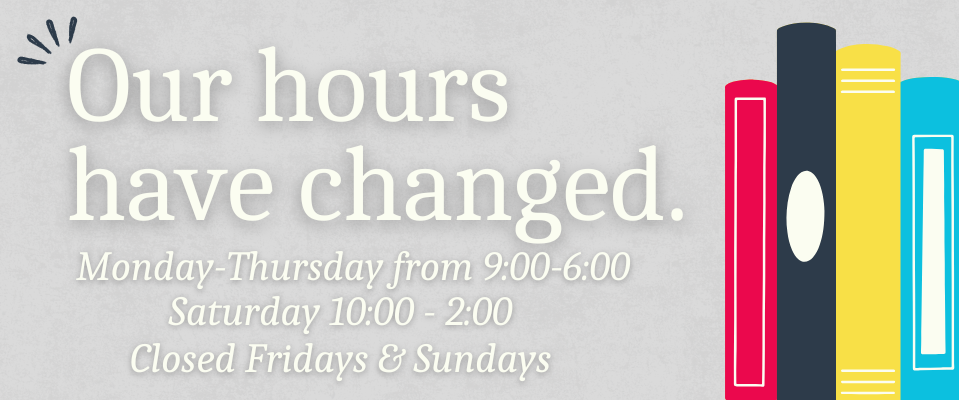 Note that Library Hours have changed beside a shelf of multi-colored books