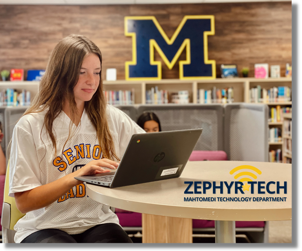 student in library with laptop sitting om the desj]k