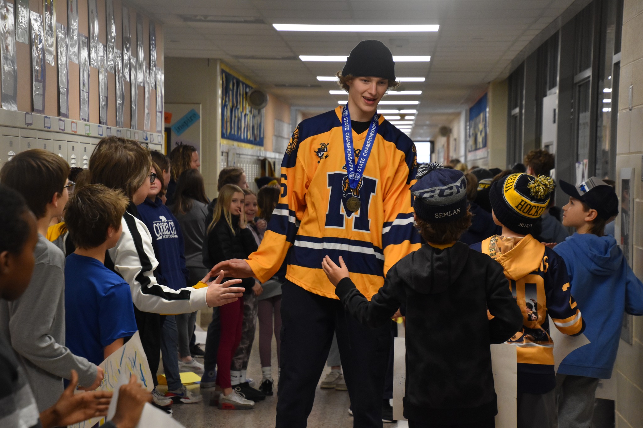Hockey player giving high fives to elementary students