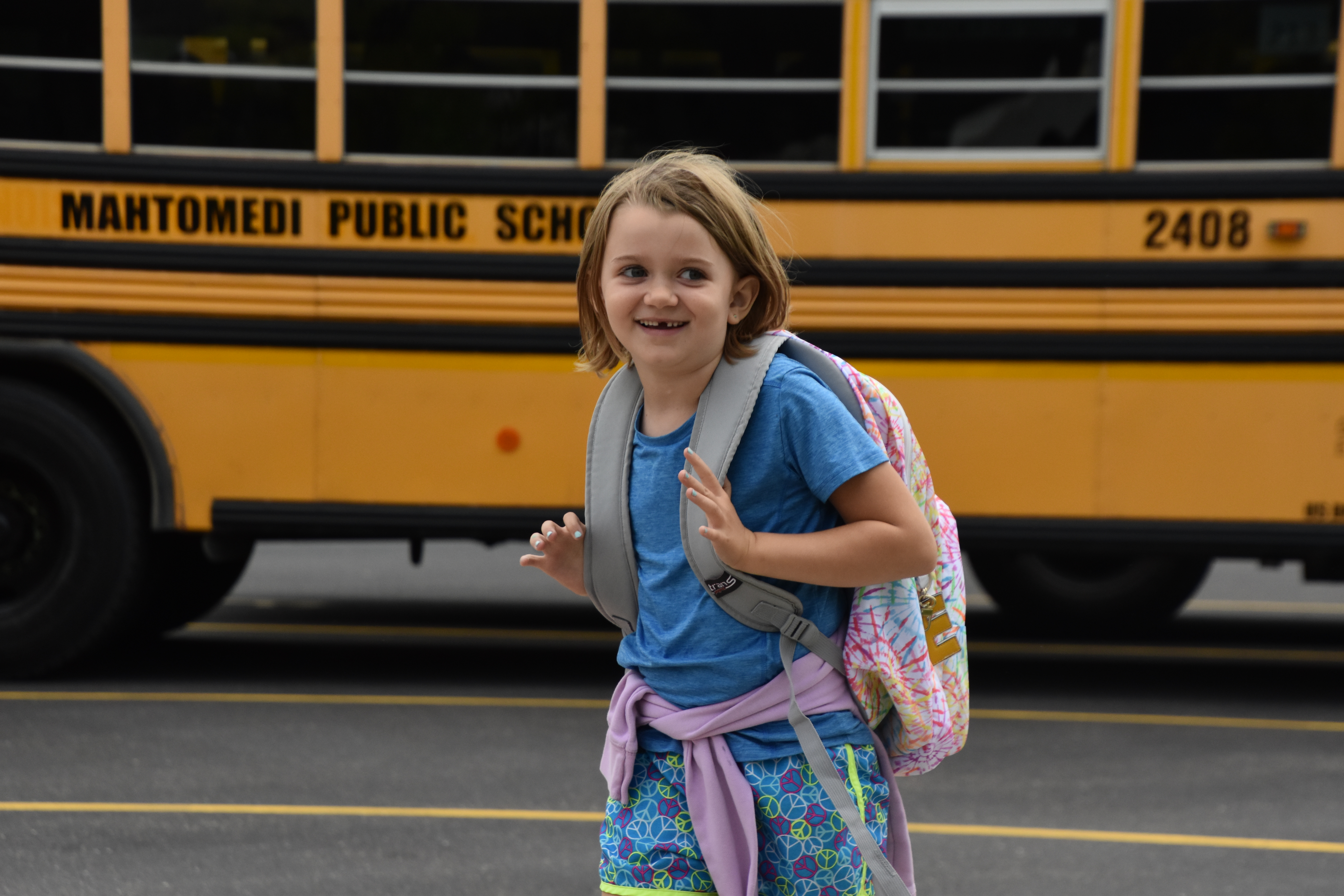 Student smiling by a school bus