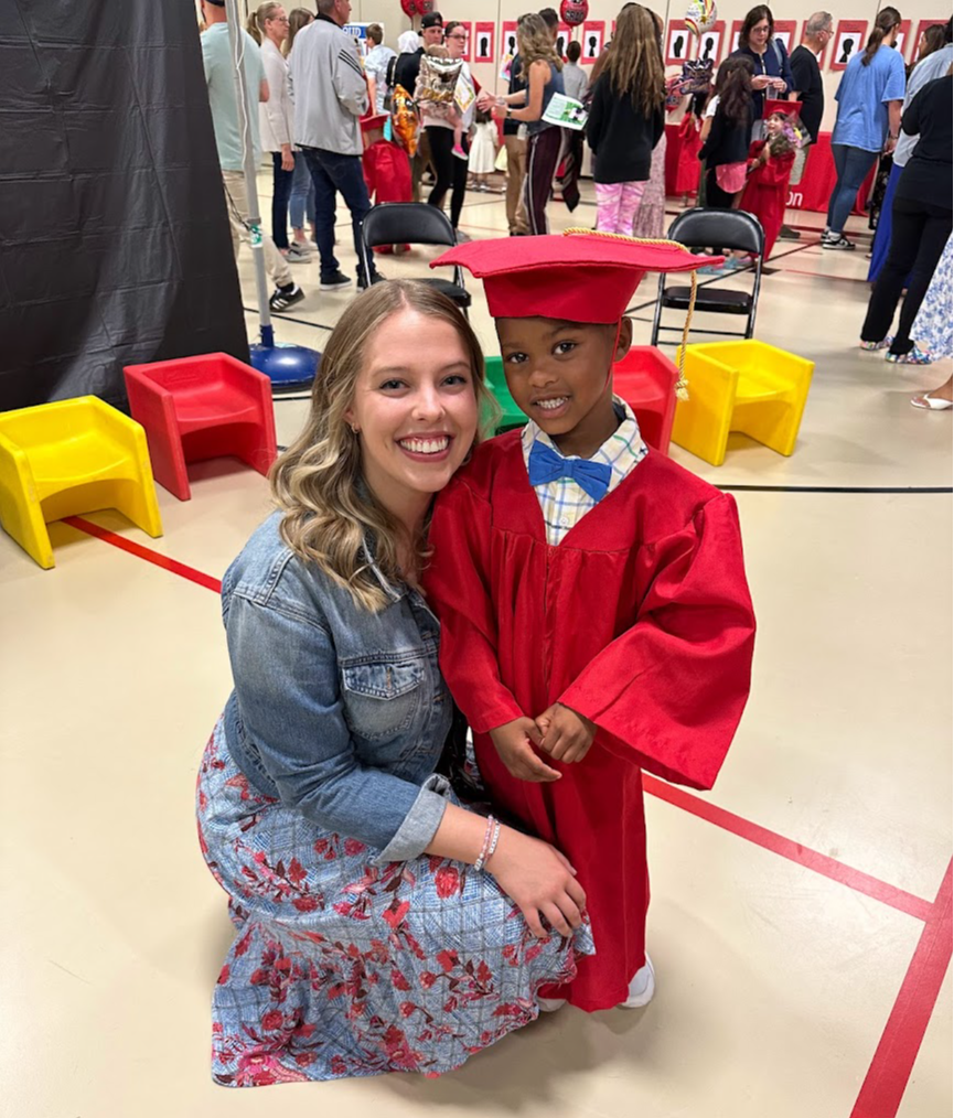Mis Heather is pictured with one of her preschool graduates in his cap & gown