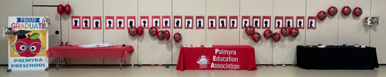 gym is all set up with balloons and silhouette pictures of the preschool grads