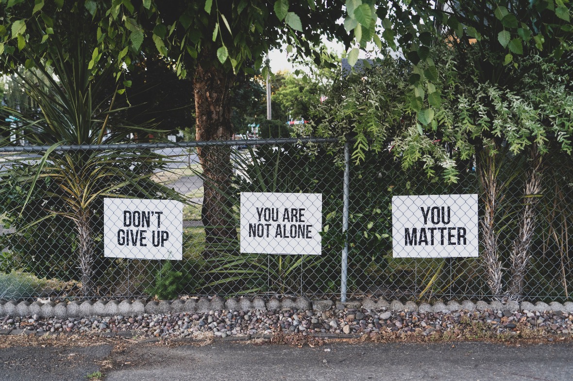 Signs on fence motivating against suicide