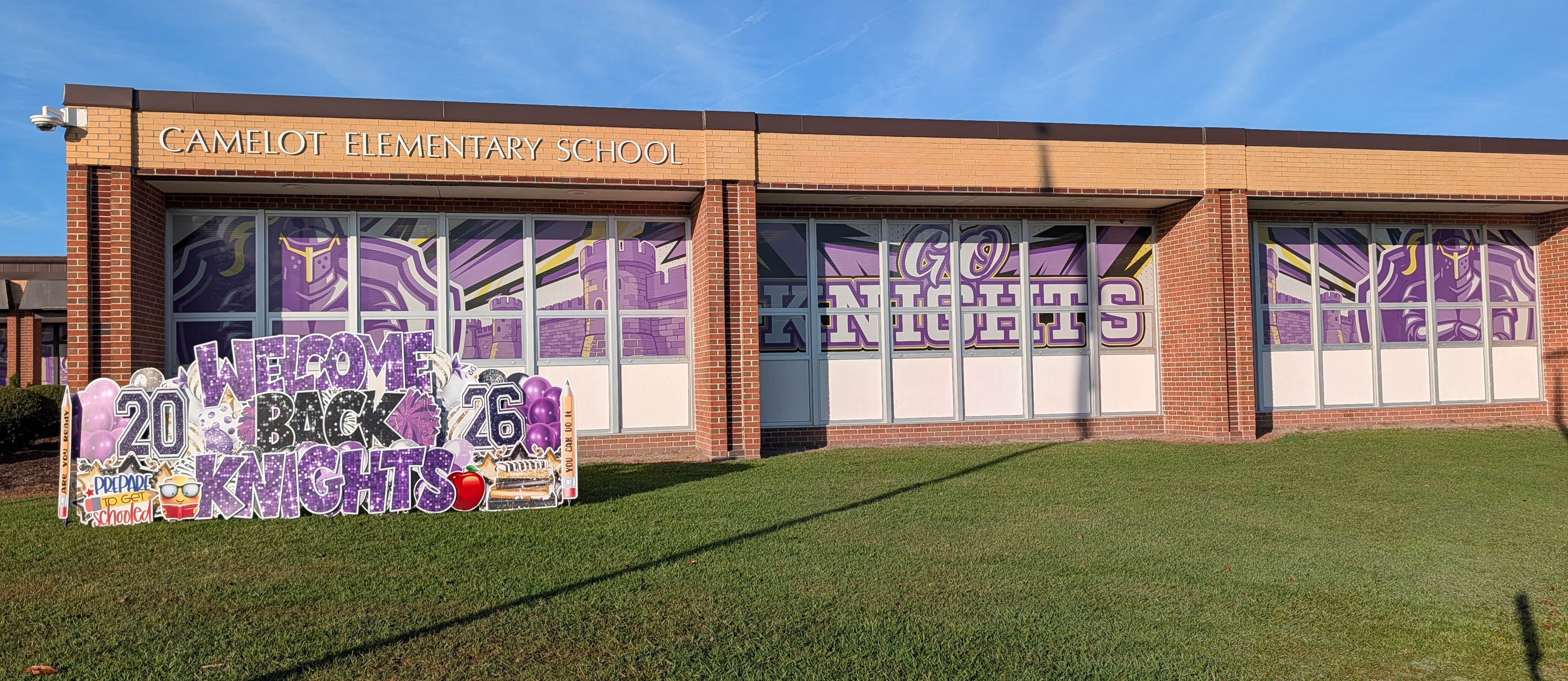 front of Camelot elementary school with welcome back knights banner
