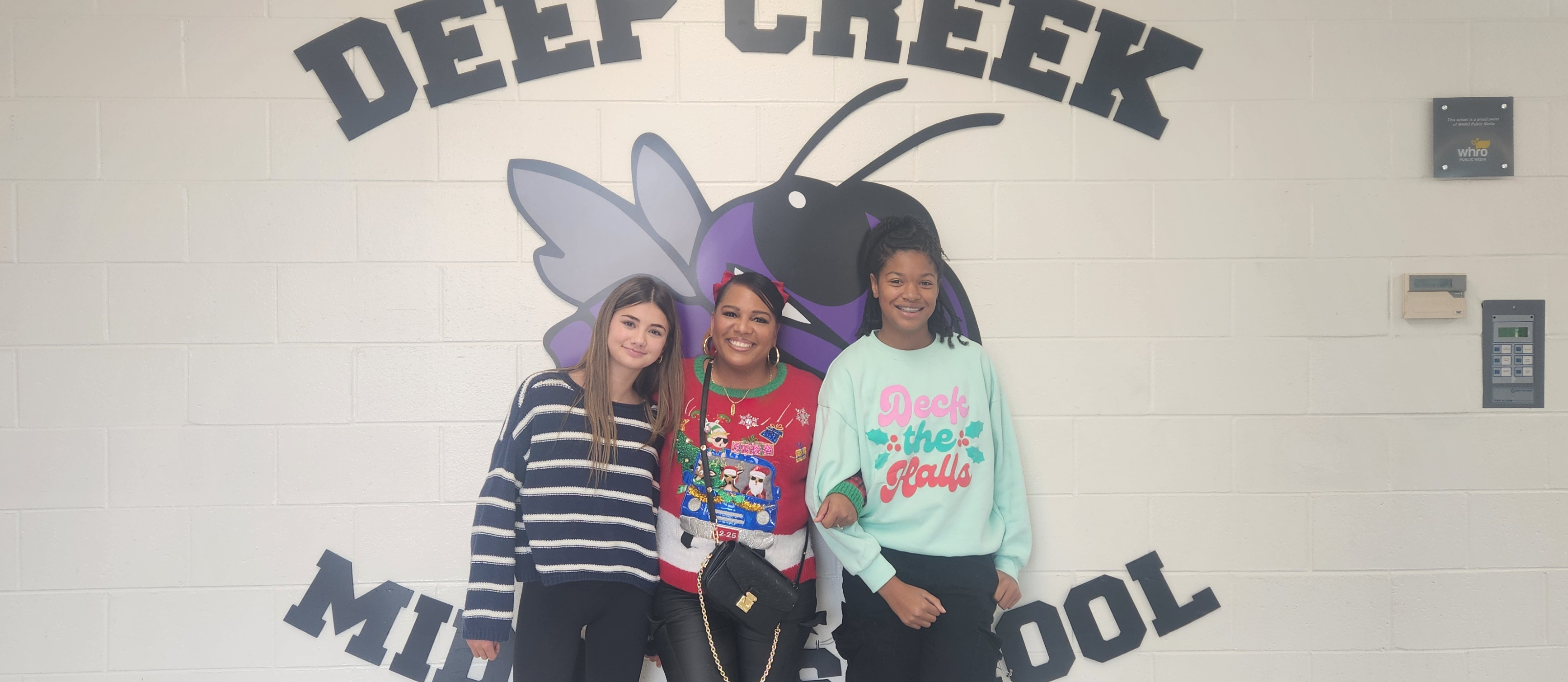A teacher and two students wearing socks and holiday wear