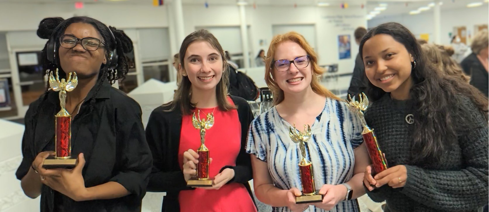 Forensics students hold their trophies and smile for the camera