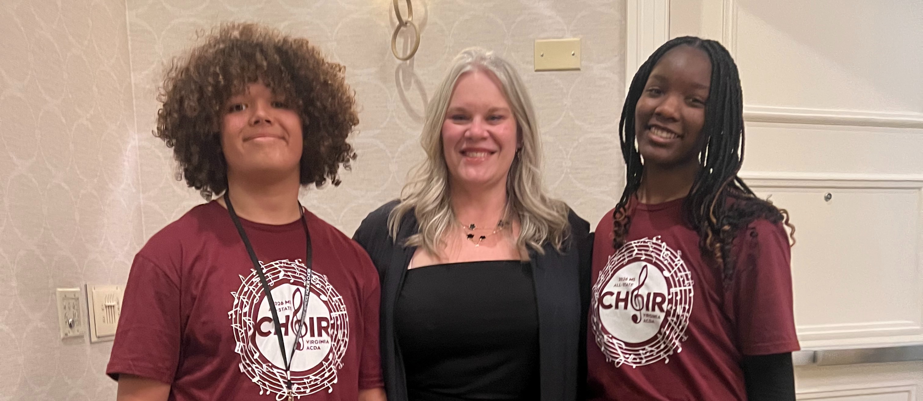 Two students standing to either side of their Chorus Teacher, Mrs. Keller, representing HOMS at the VA Middle School Honors Chorus event in Richmond, VA April 16-17 for the Mixed Choir.