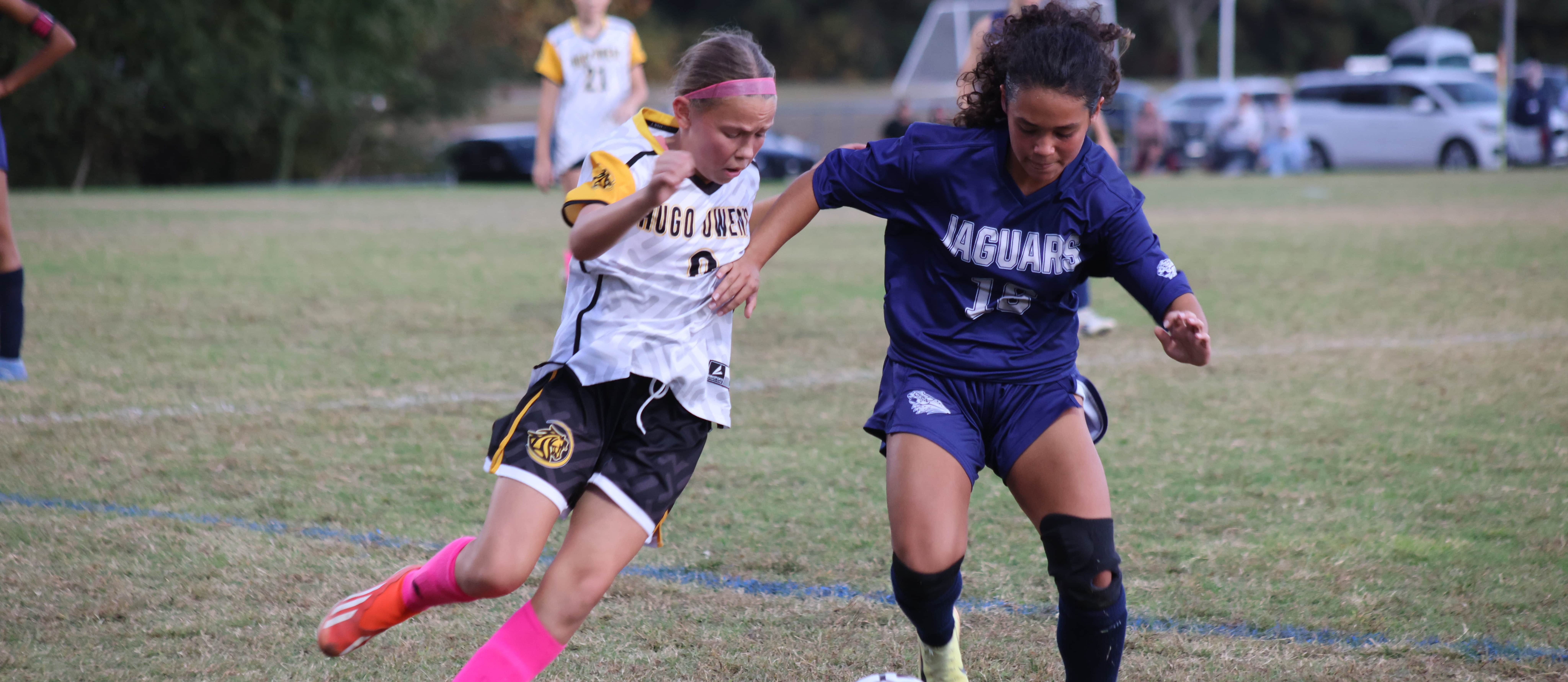 A JMS student competes for possession of the ball with a HOMS player during the CMSL Girls Soccer championship game