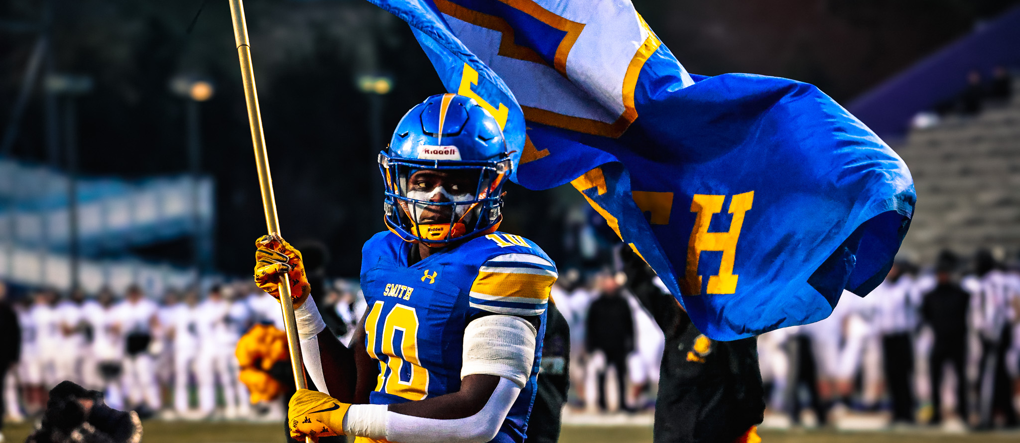 A OSHS football players waves the flag before a playoff game