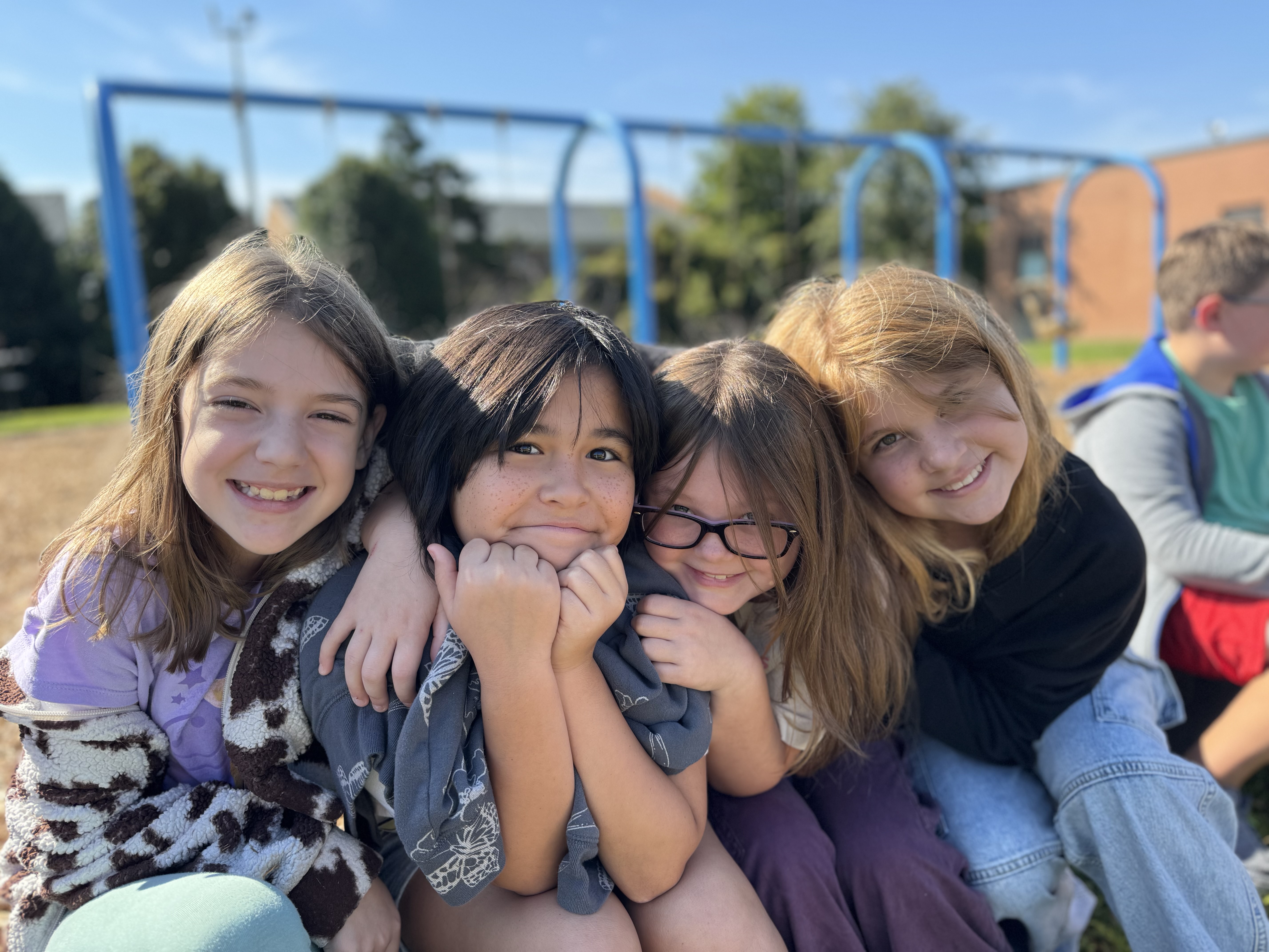 Four girls on the playground sitting down