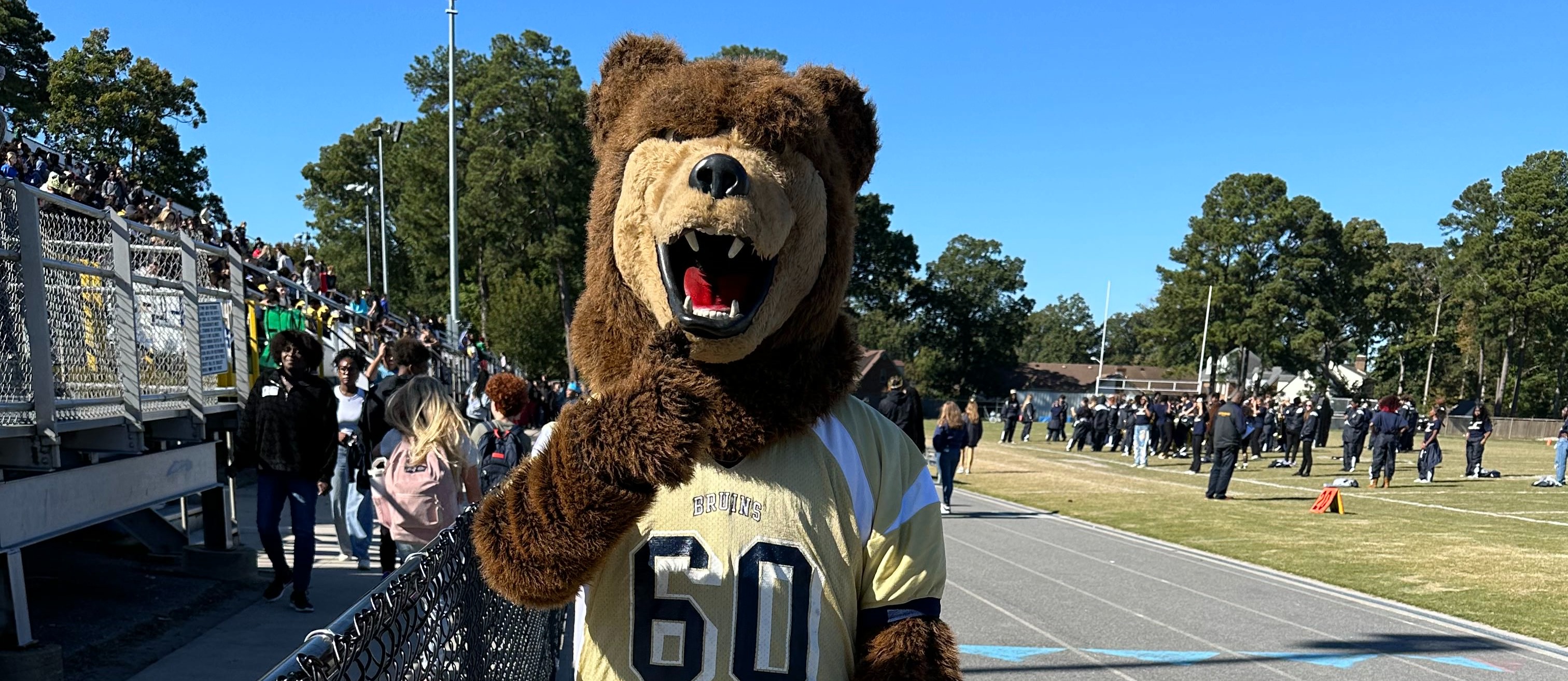 western branch high school  bruin bear mascot in a football jersey outside on the track during the pep rally.