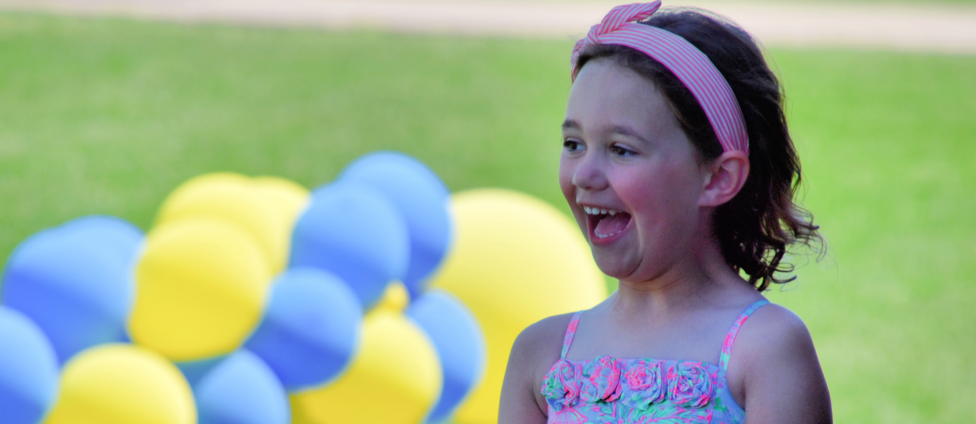 Student smiling outside with balloons