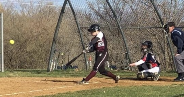 girl about hitting the ball with the bat on the softball field