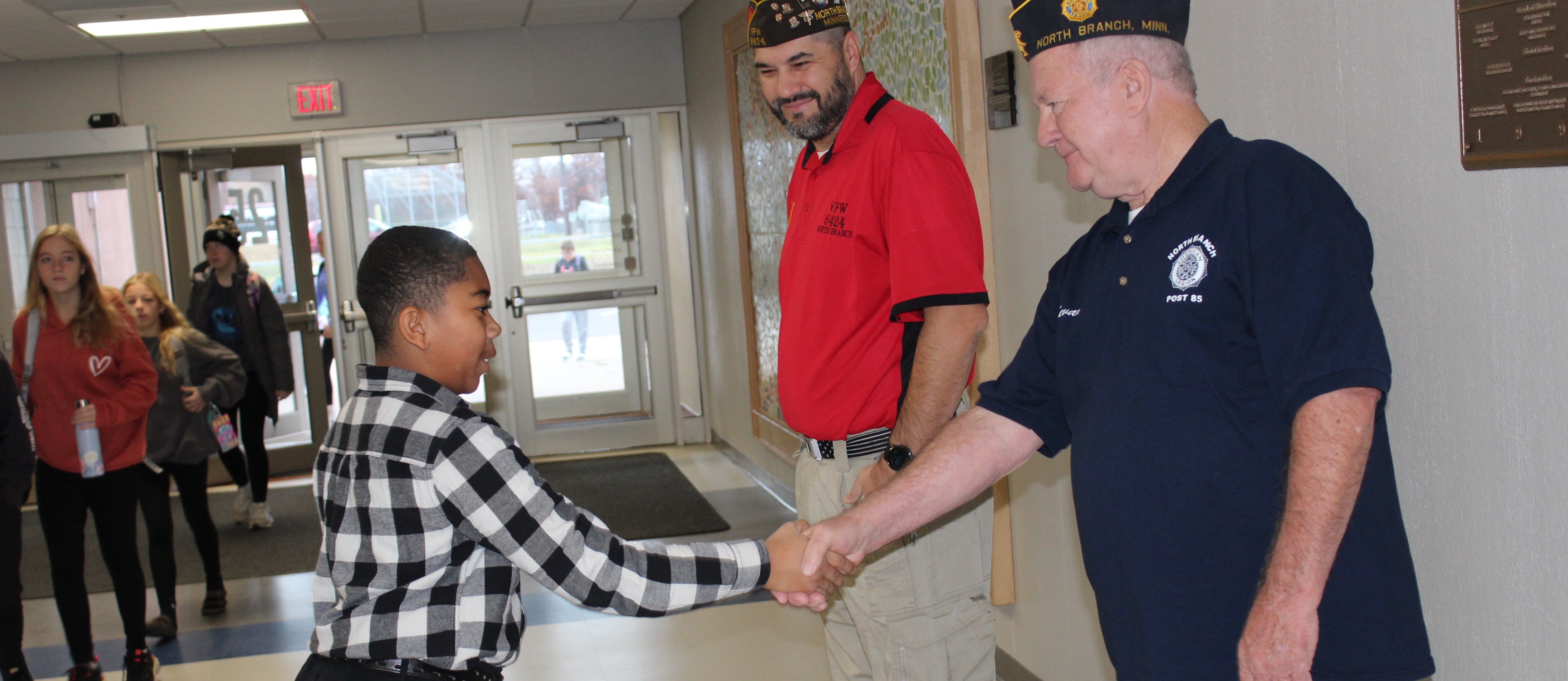 Student shaking hands with veteran