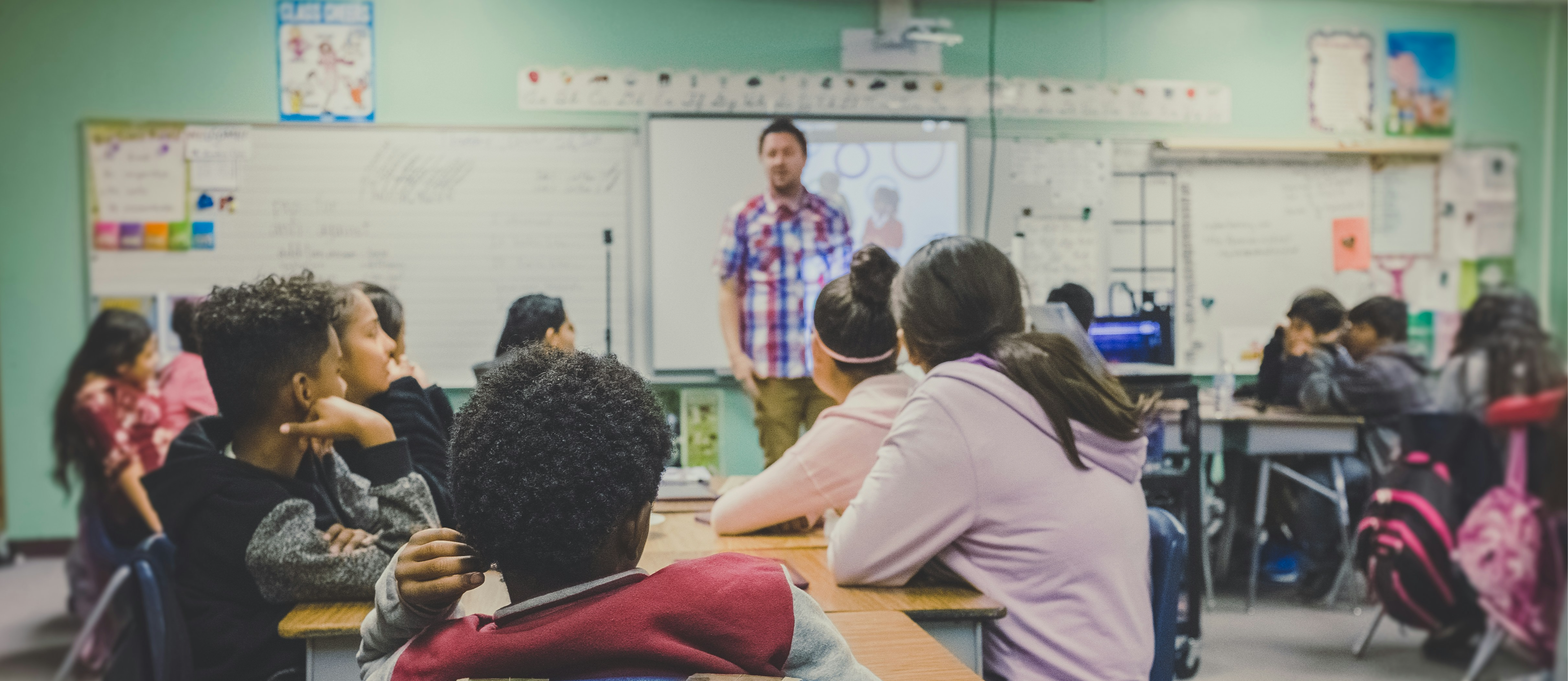 Male Teacher in front of students teaching