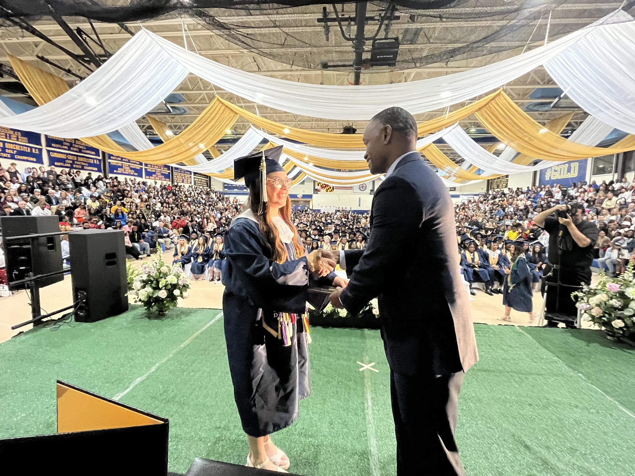 superintendent handing out a diploma to a student