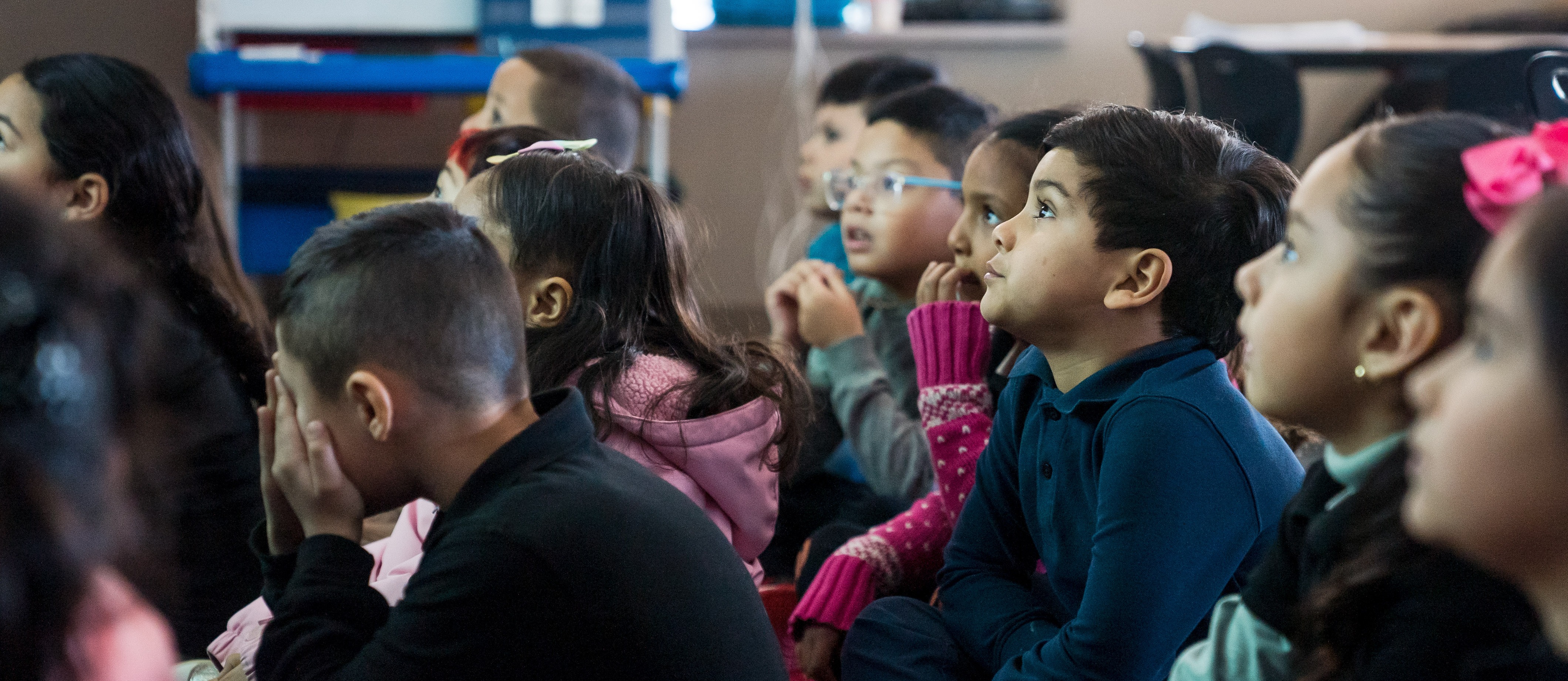 Elementary Students in classroom looking towards screen
