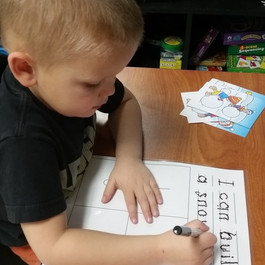 Kid writing in his book