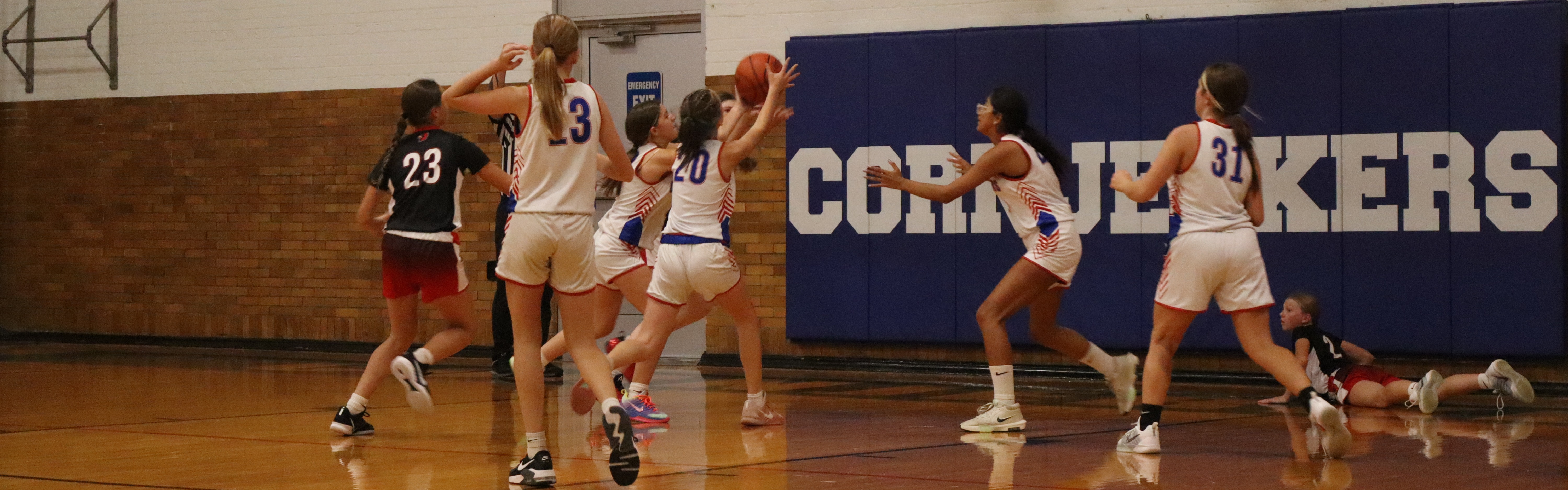 8th grade girls basketball going for a rebound.