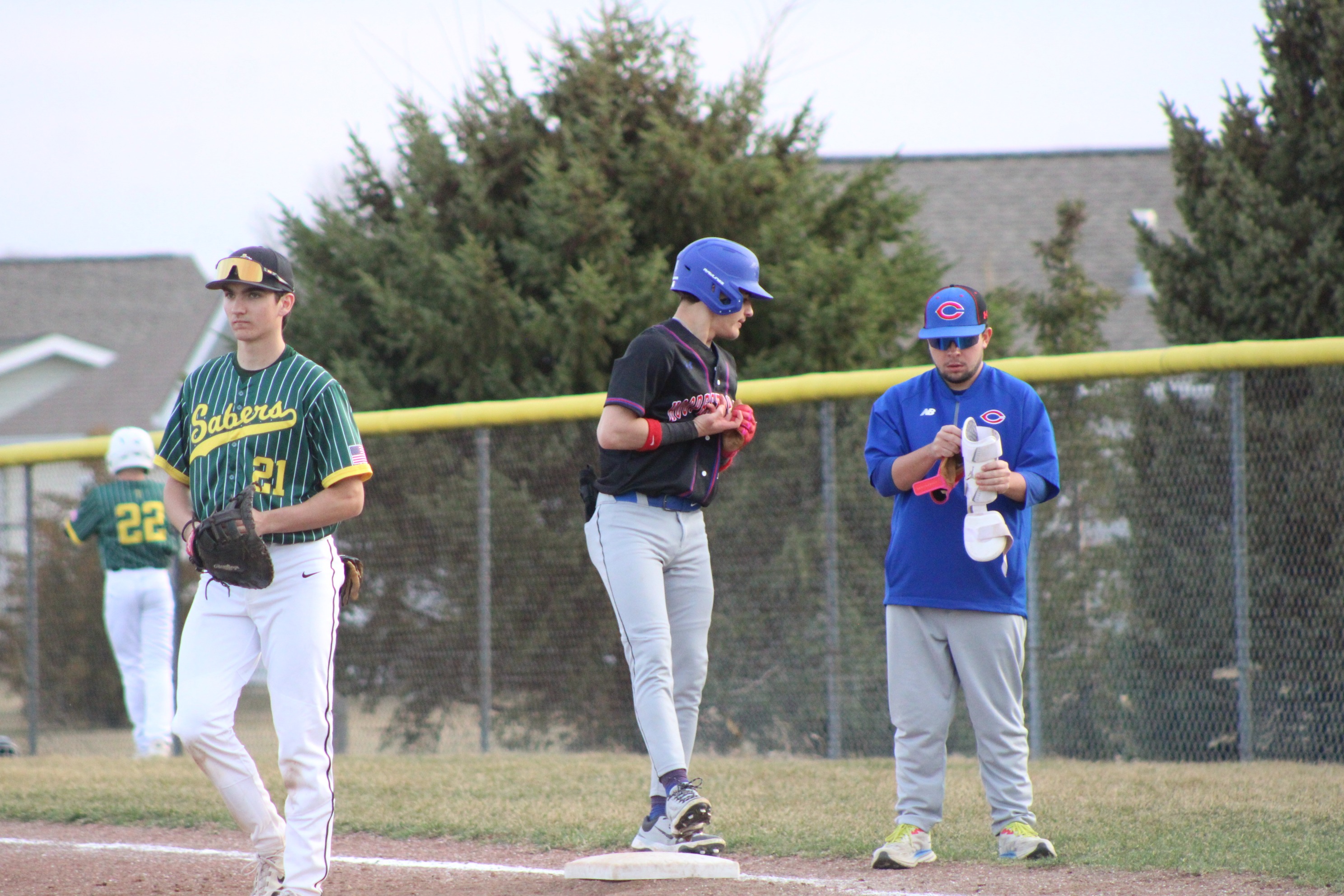 Baseball- on fiorst base talking to coach.