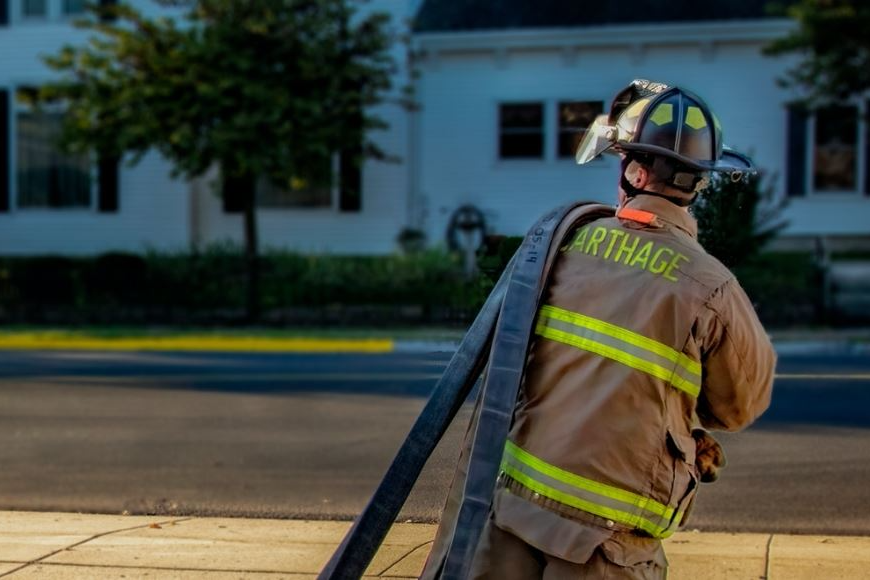 fire fighter carrying hose